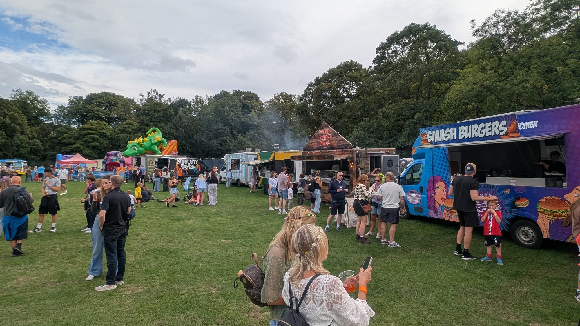 Oughtifest visitors beside food vans on the grass at the real event.